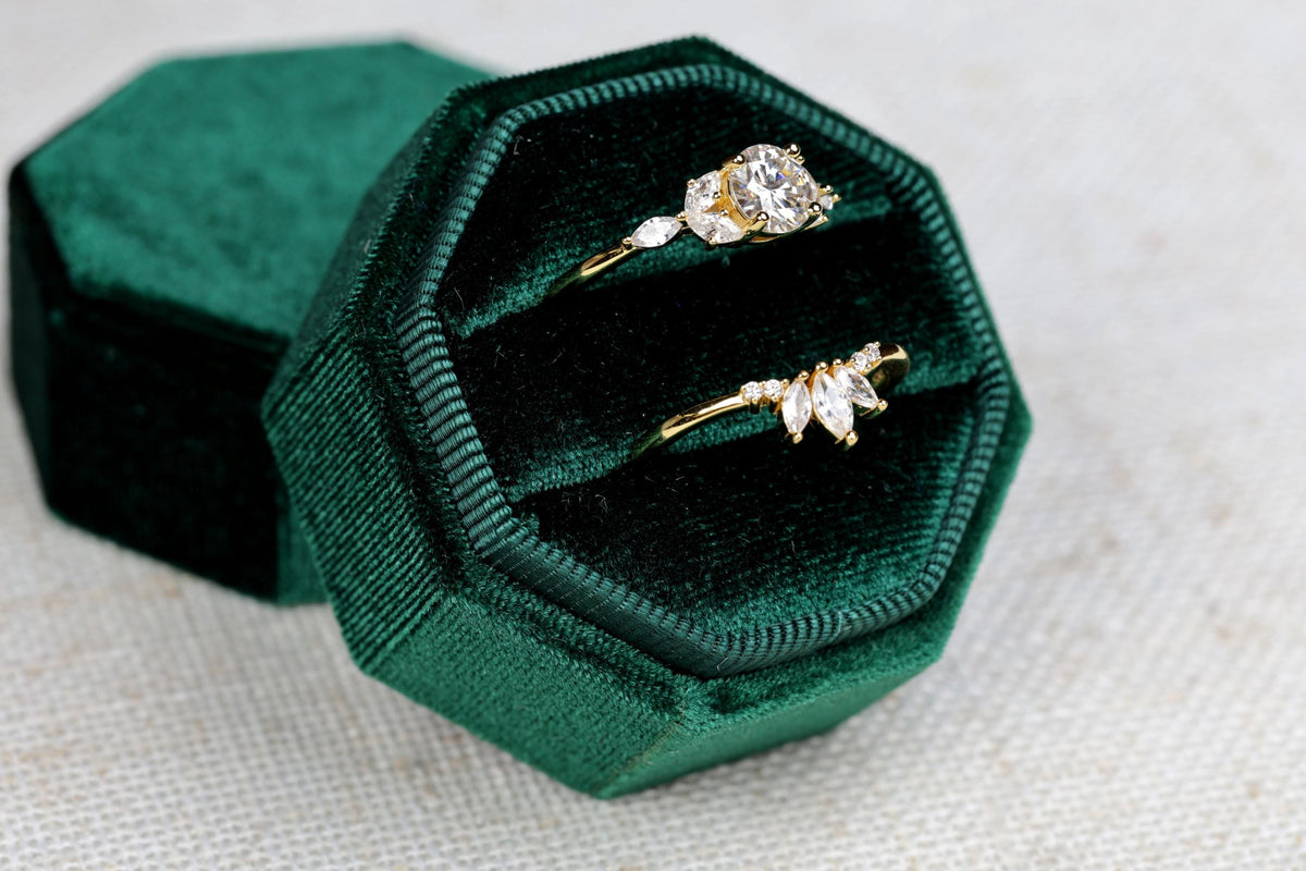 a couple of rings sitting inside of a green velvet box