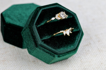 a couple of rings sitting inside of a green velvet box