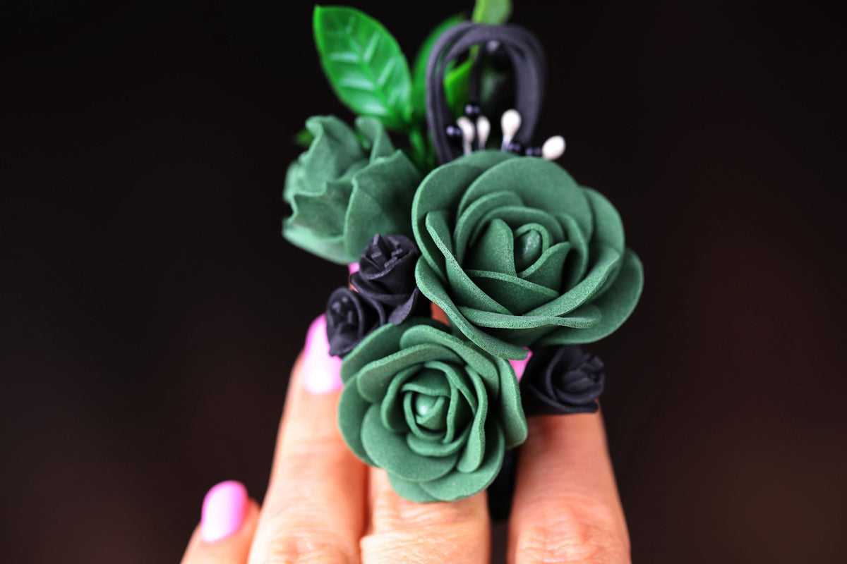 a woman's hand holding a ring with flowers on it