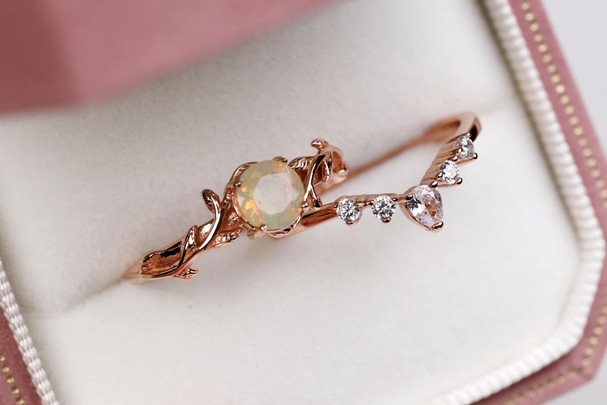 a gold ring with an opal surrounded by diamonds
