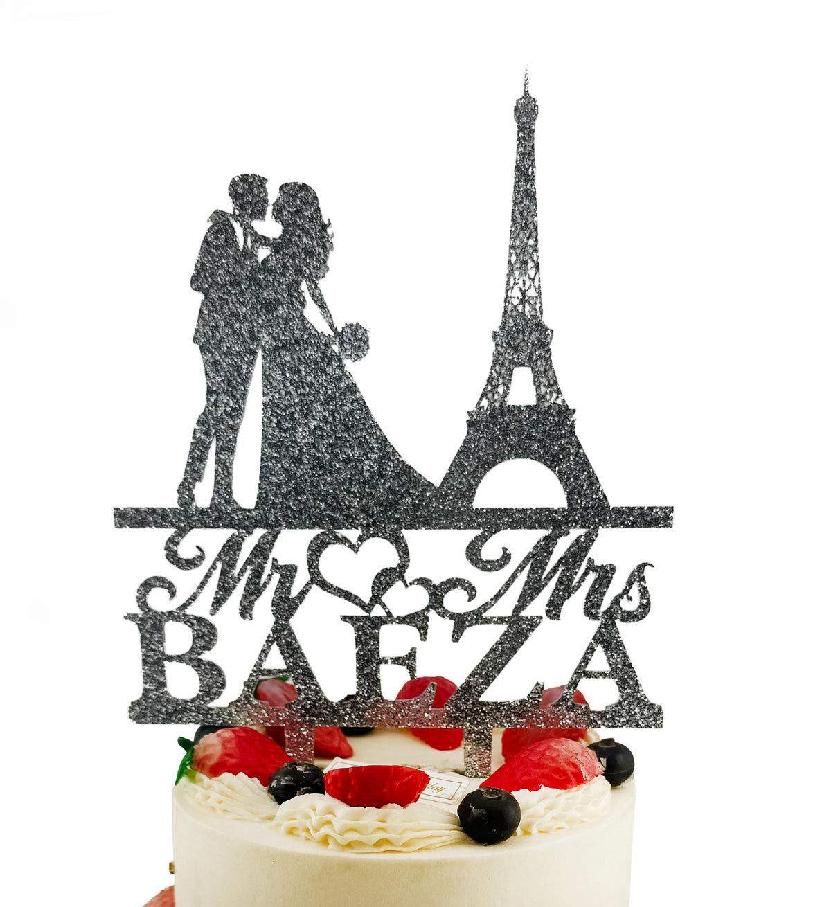 A wedding cake with a decorative topper featuring a silhouette of a couple embracing, with the words "Mr & Mrs Baffe" written on the cake.