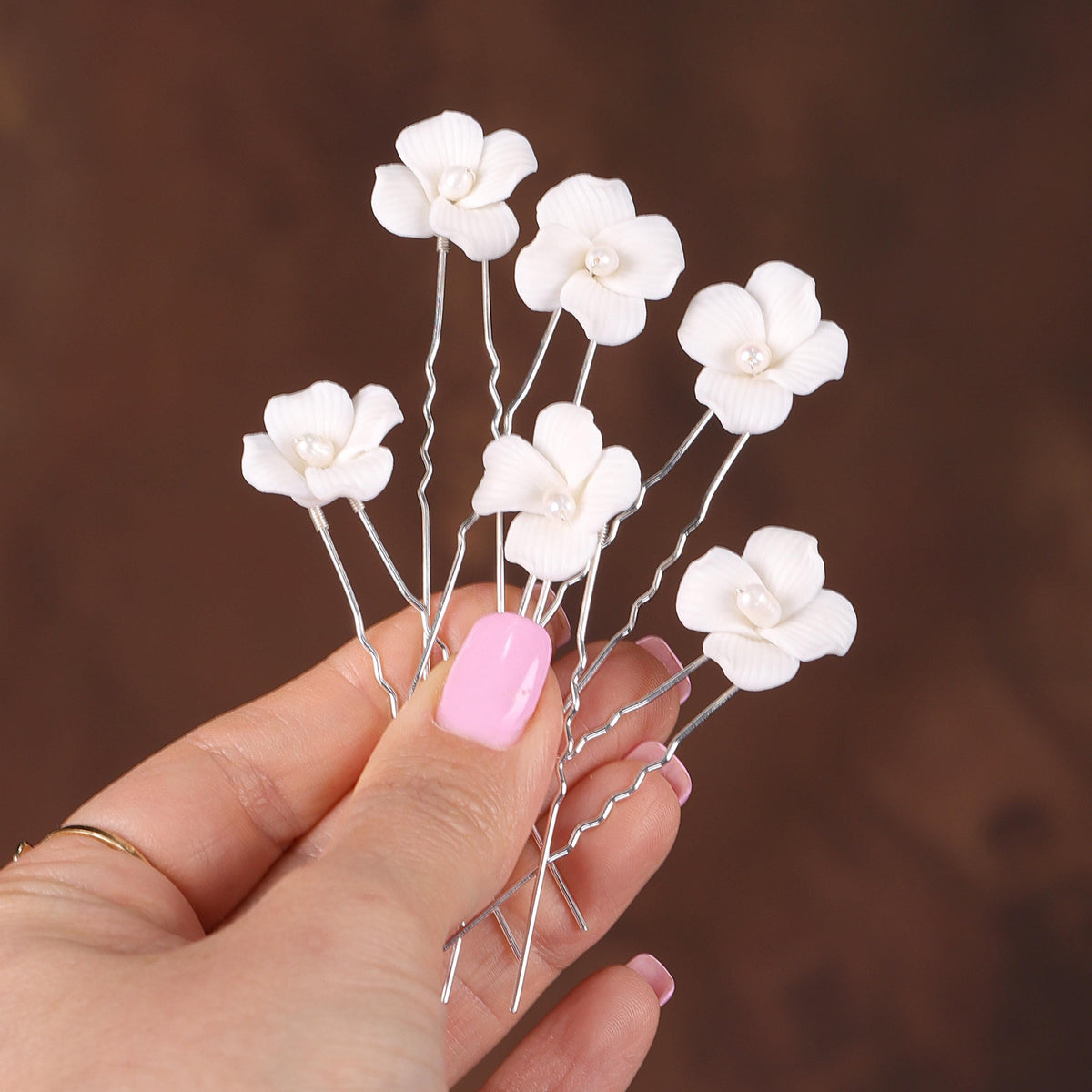 a hand holding a bunch of white flowers