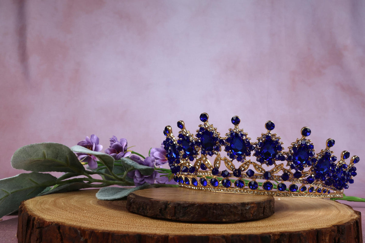 a blue tiara sitting on top of a tree stump