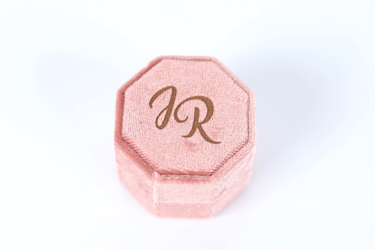 A pink velvet box with the initials "JR" printed on it.