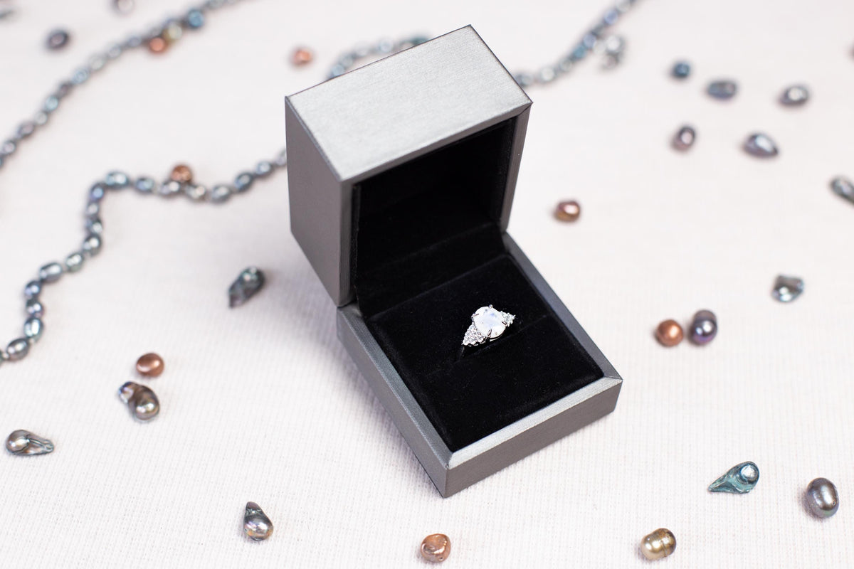 a ring sits inside of a box on a chain