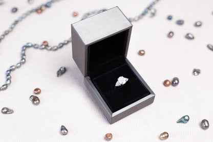 a ring sits inside of a box on a chain