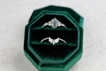 a couple of rings sitting on top of a green velvet box
