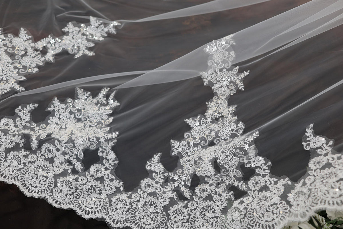 a close up of a wedding veil with flowers on it