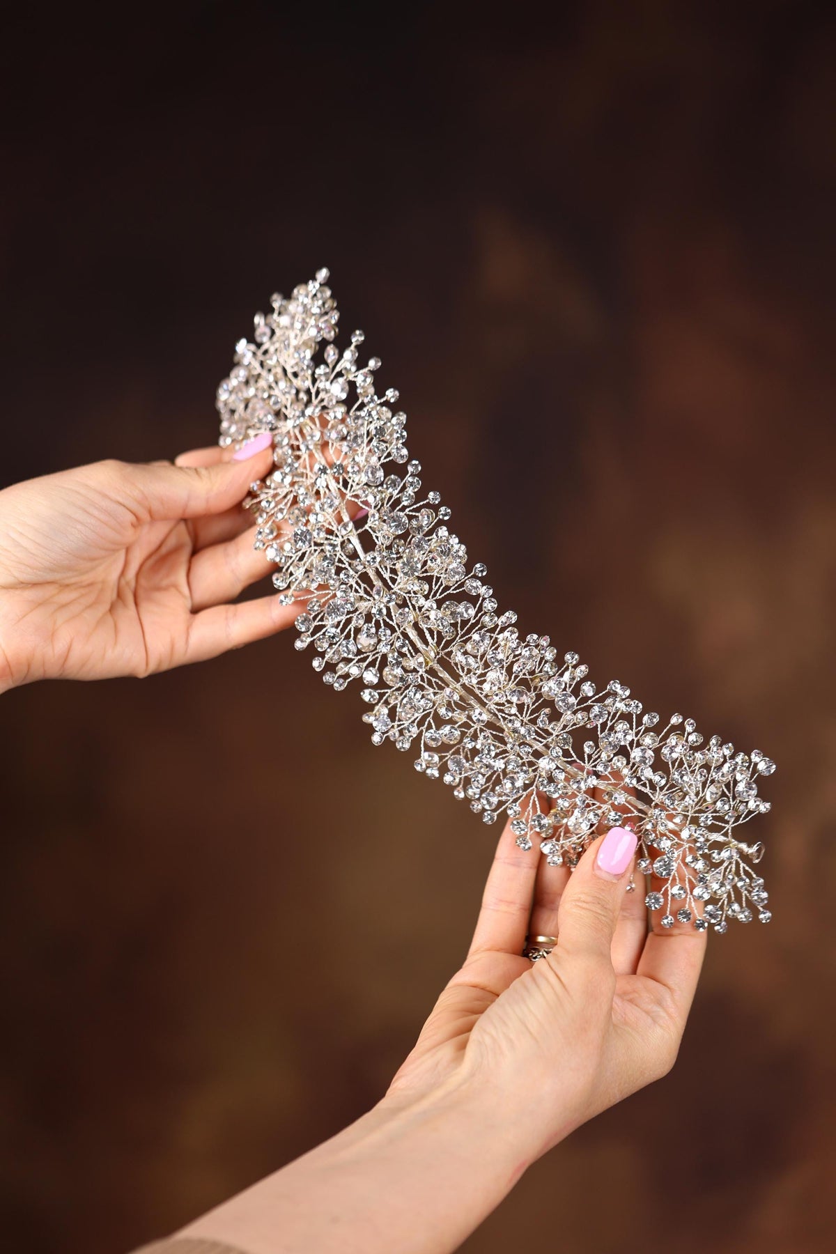 a woman holding a tiara in her hands