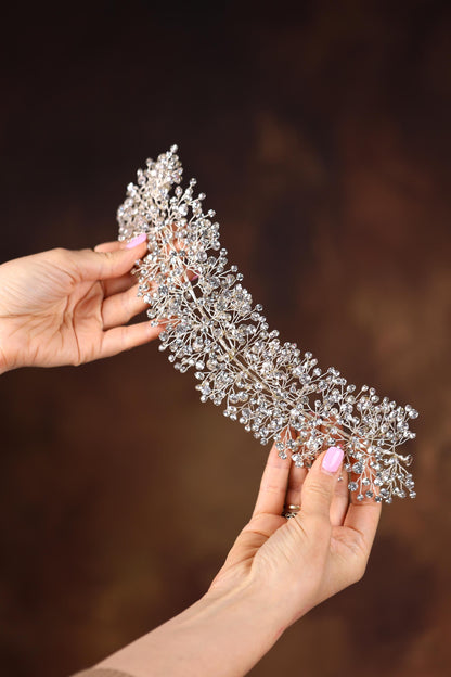a woman holding a tiara in her hands