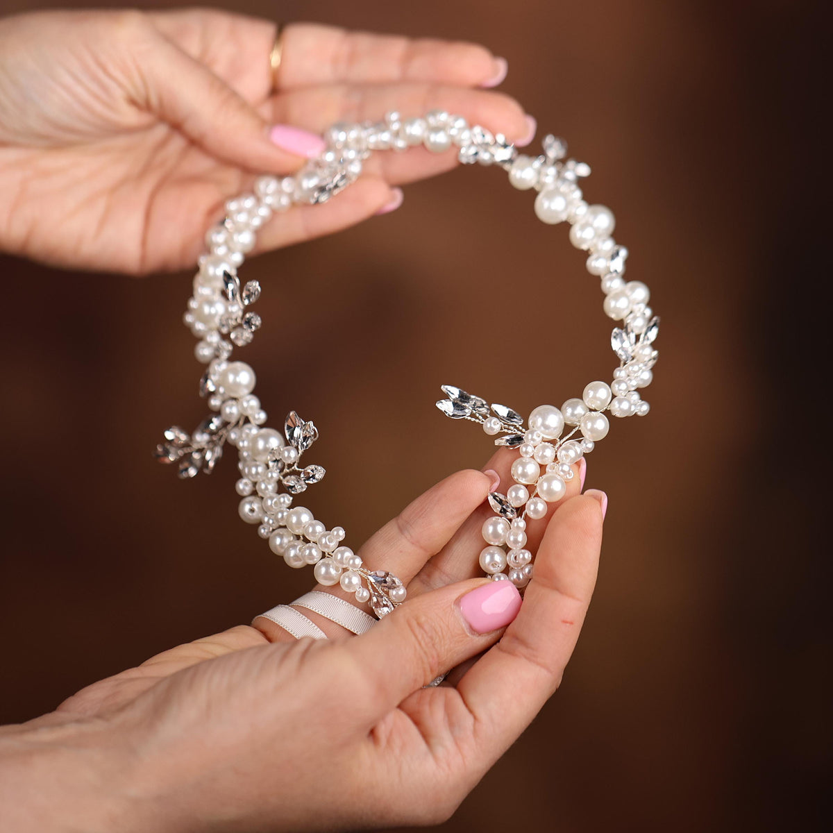 a woman holding a necklace with a cross on it