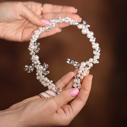 a woman holding a necklace with a cross on it