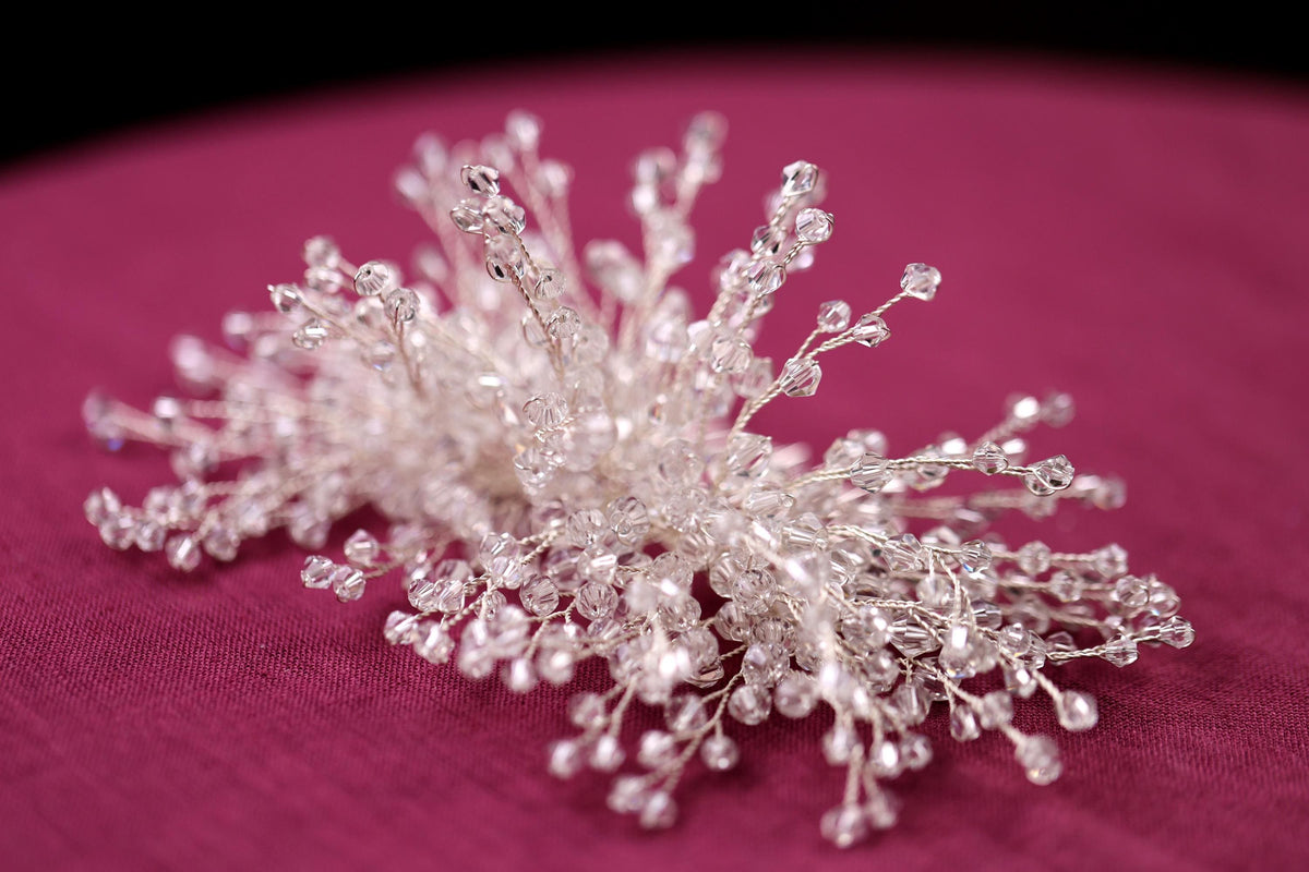 a close up of a small crystal snowflake on a pink surface