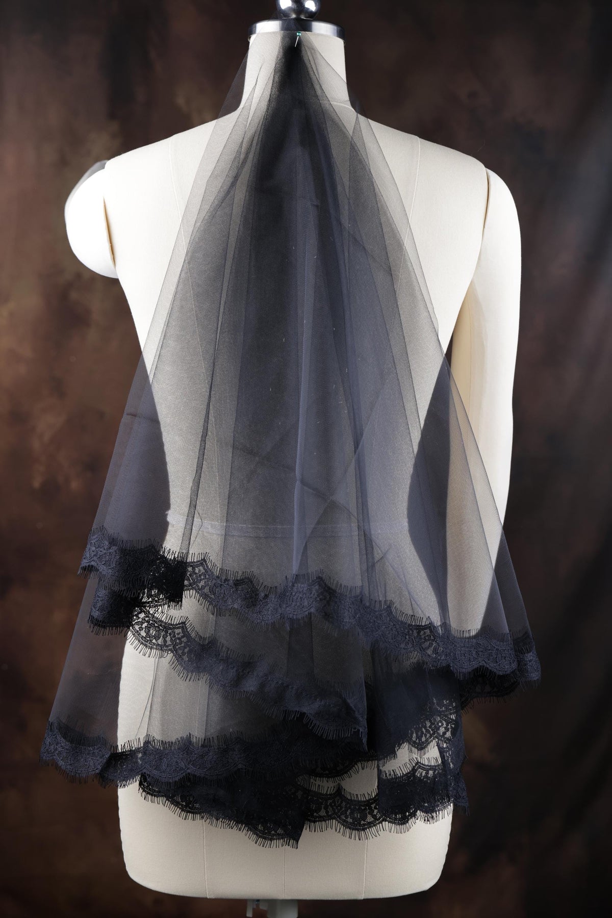 a white mannequin with a black veil on top of it