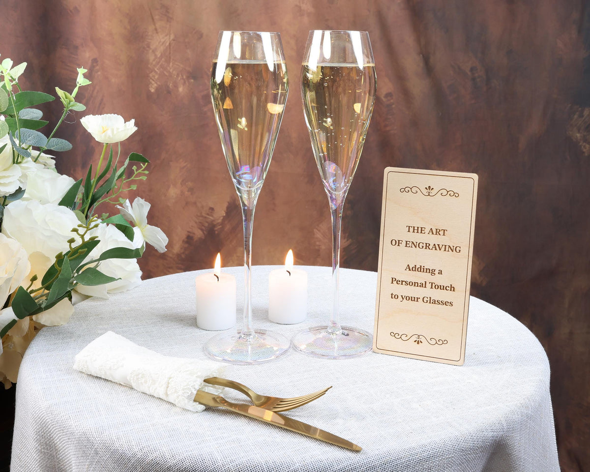 a table topped with two champagne flutes and a sign