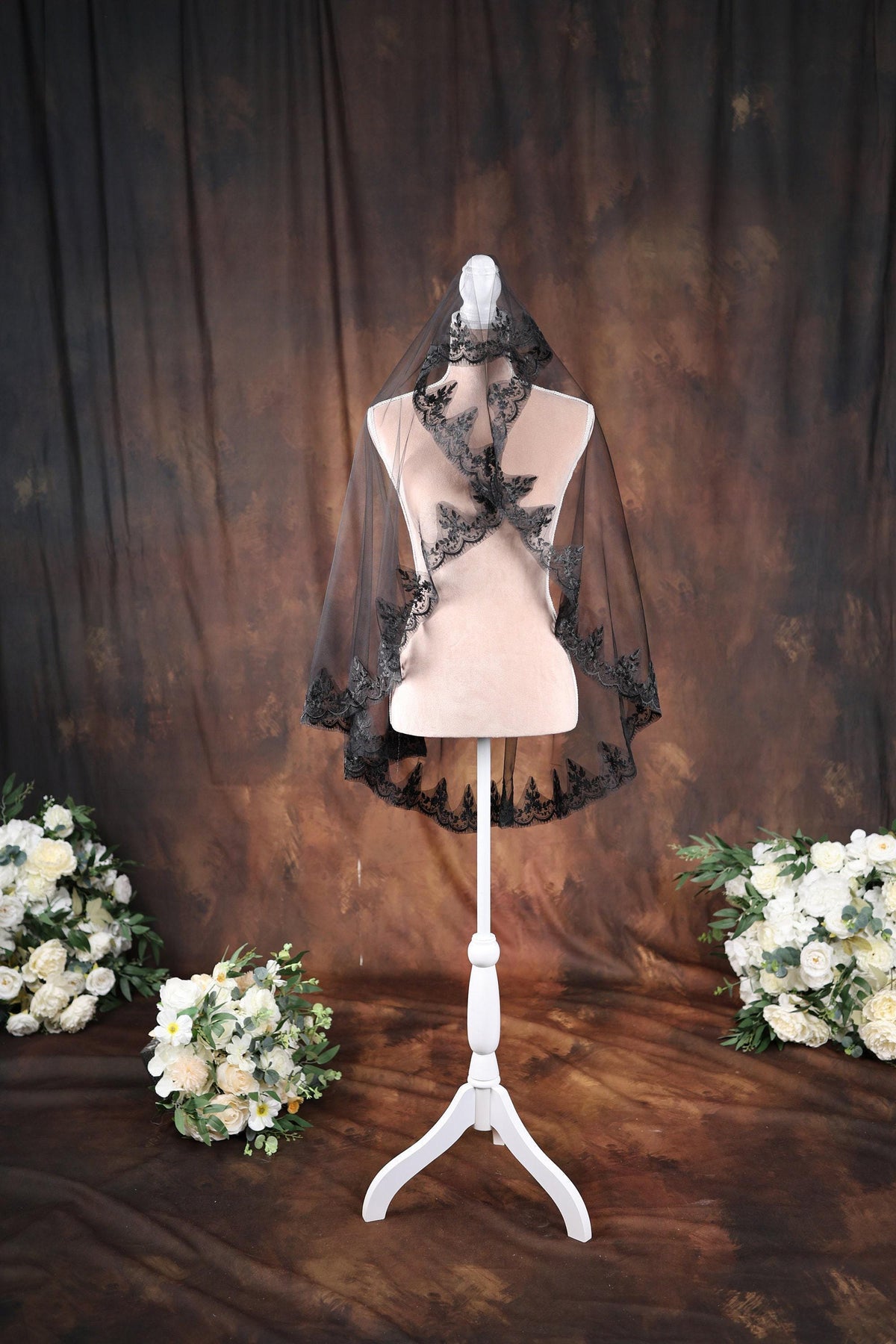 a white mannequin with a black veil on top of it