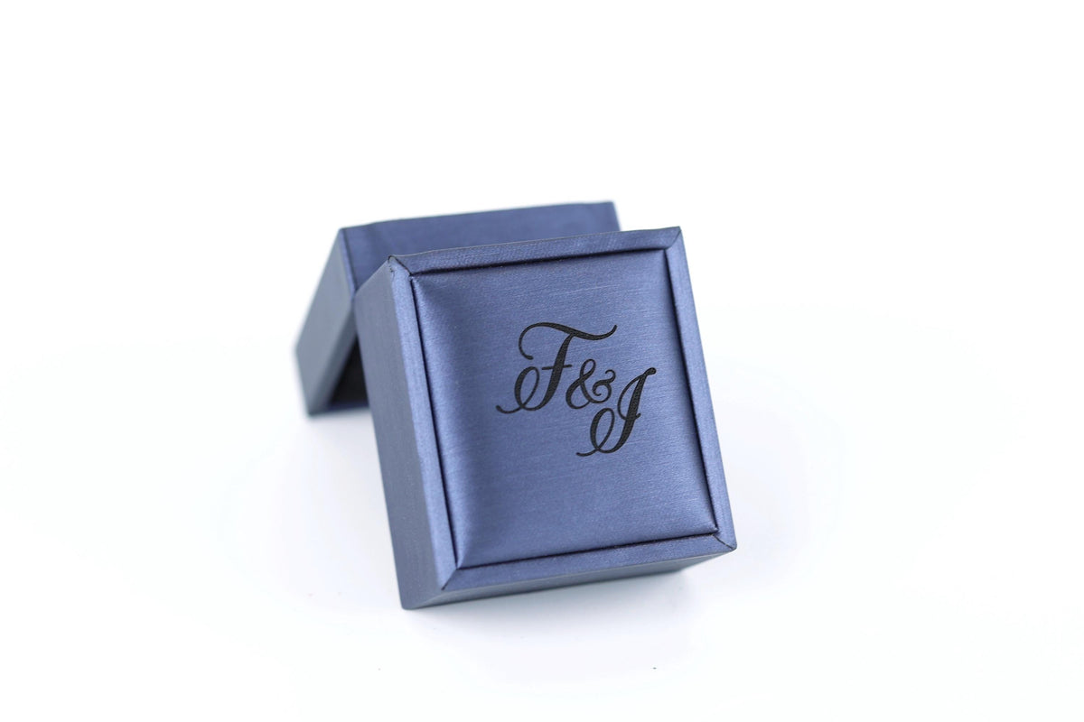 A blue jewelry box with the text "F&J" printed on it.