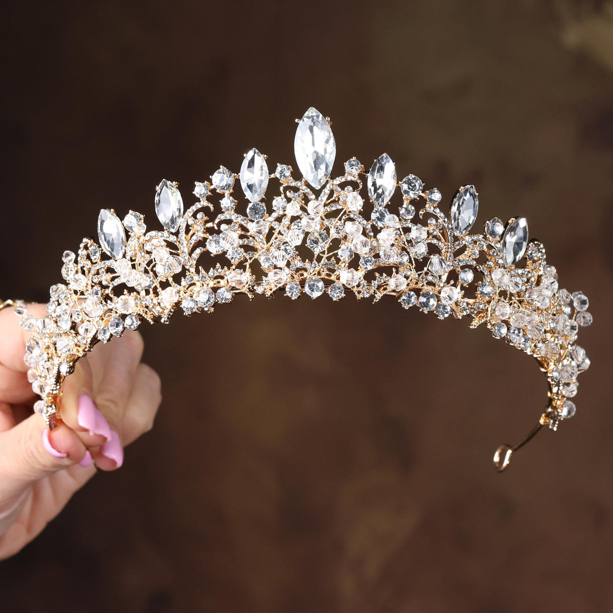 a close up of a person holding a tiara