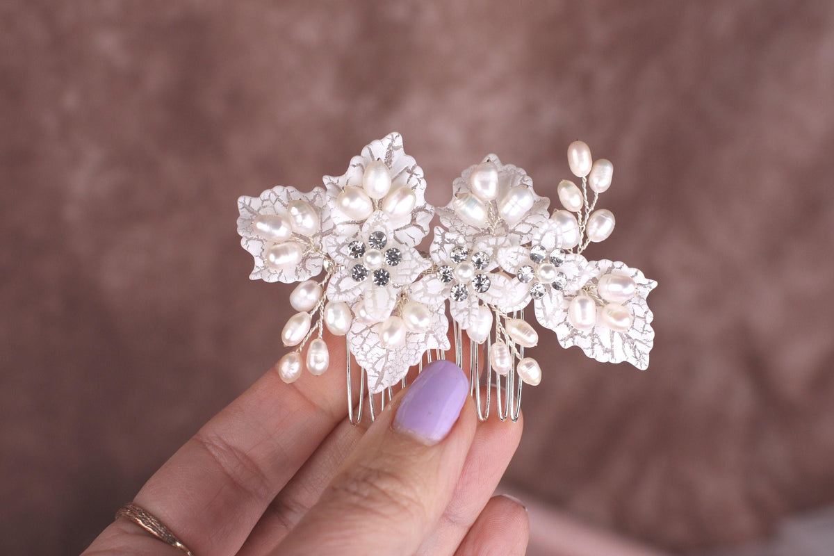 a woman's hand holding a hair comb with flowers on it