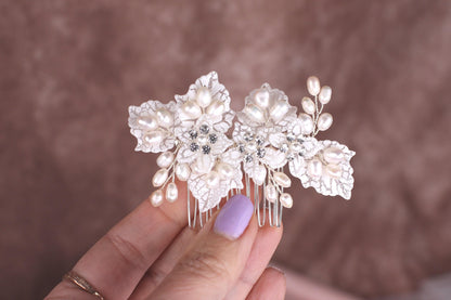 a woman's hand holding a hair comb with flowers on it