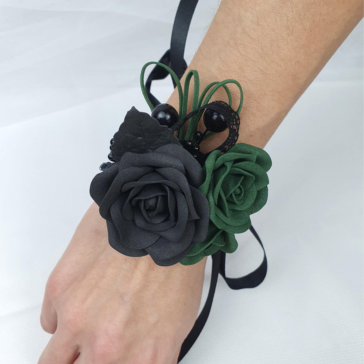 a person wearing a black and green flower bracelet