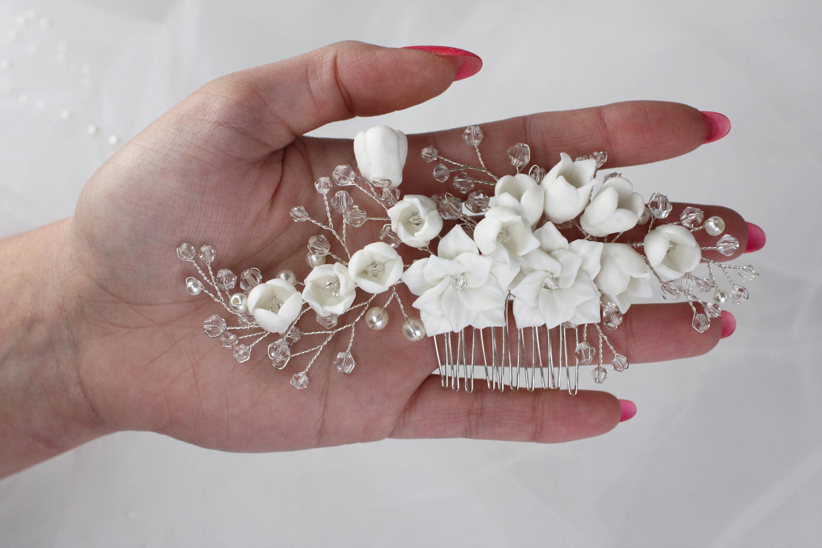 a woman's hand holding a comb with flowers on it