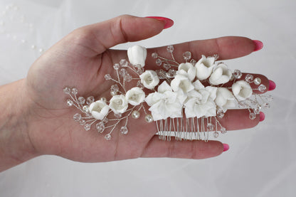 a woman's hand holding a comb with flowers on it